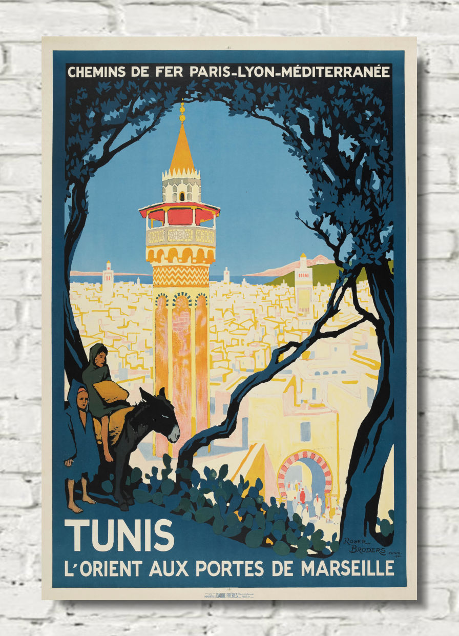 A vintage-style travel poster for Tunis, France, featuring a tower, trees, and a rider on horseback, displayed against a white brick wall background.