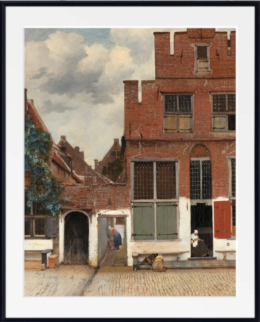Johannes Vermeer Fine Art Print : The Little Street, Delft  A framed art print depicting a classic Dutch street scene with brick buildings, cobblestone pavement, and a cloudy sky, presented with a white mat and black frame.