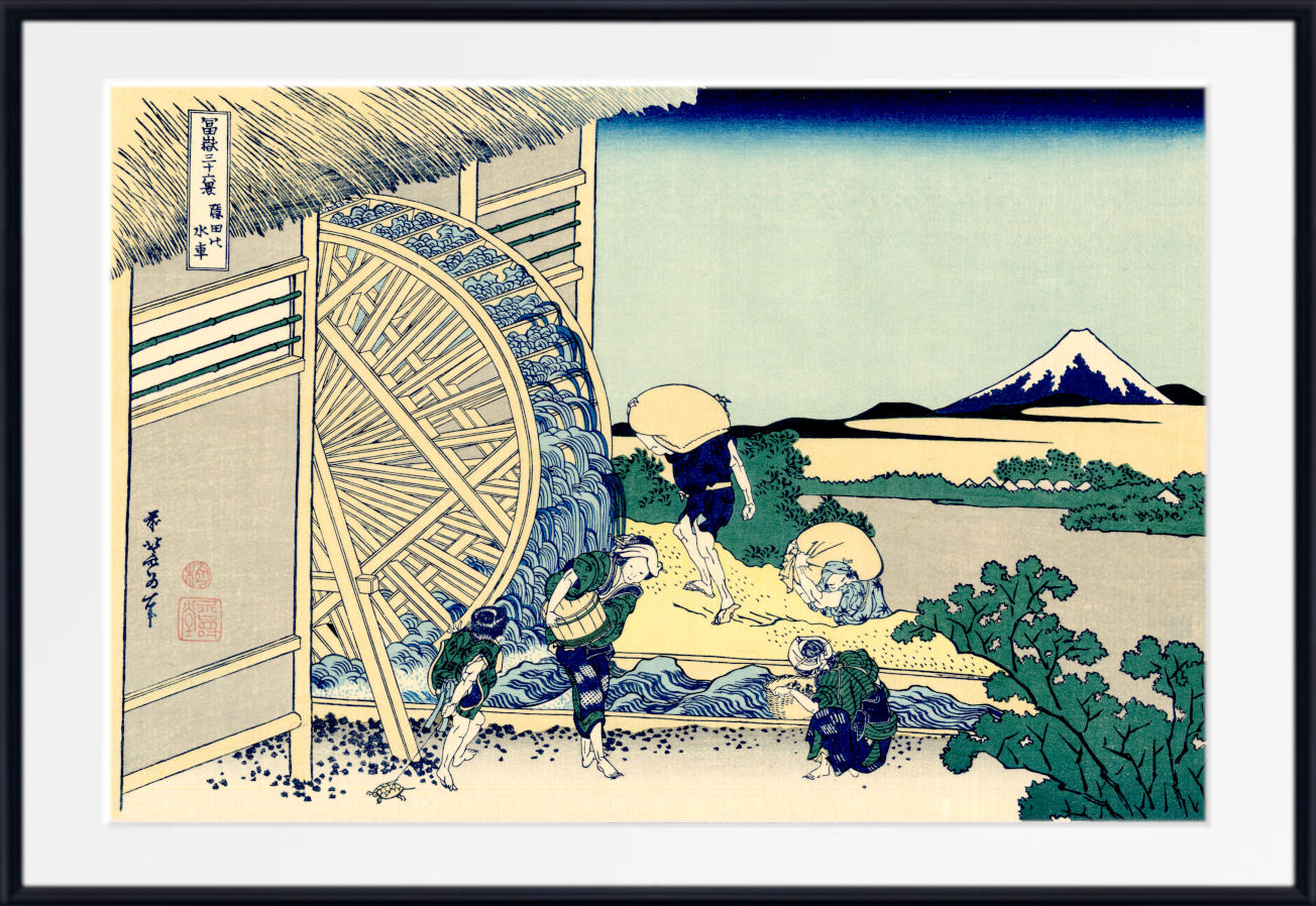 A framed Japanese ukiyo-e woodblock print depicting workers operating a large water wheel beside a river, with Mount Fuji in the distance. The artwork is shown with a white mat and a black frame.