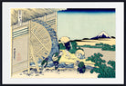 A framed Japanese ukiyo-e woodblock print depicting workers operating a large water wheel beside a river, with Mount Fuji in the distance. The artwork is shown with a white mat and a black frame.