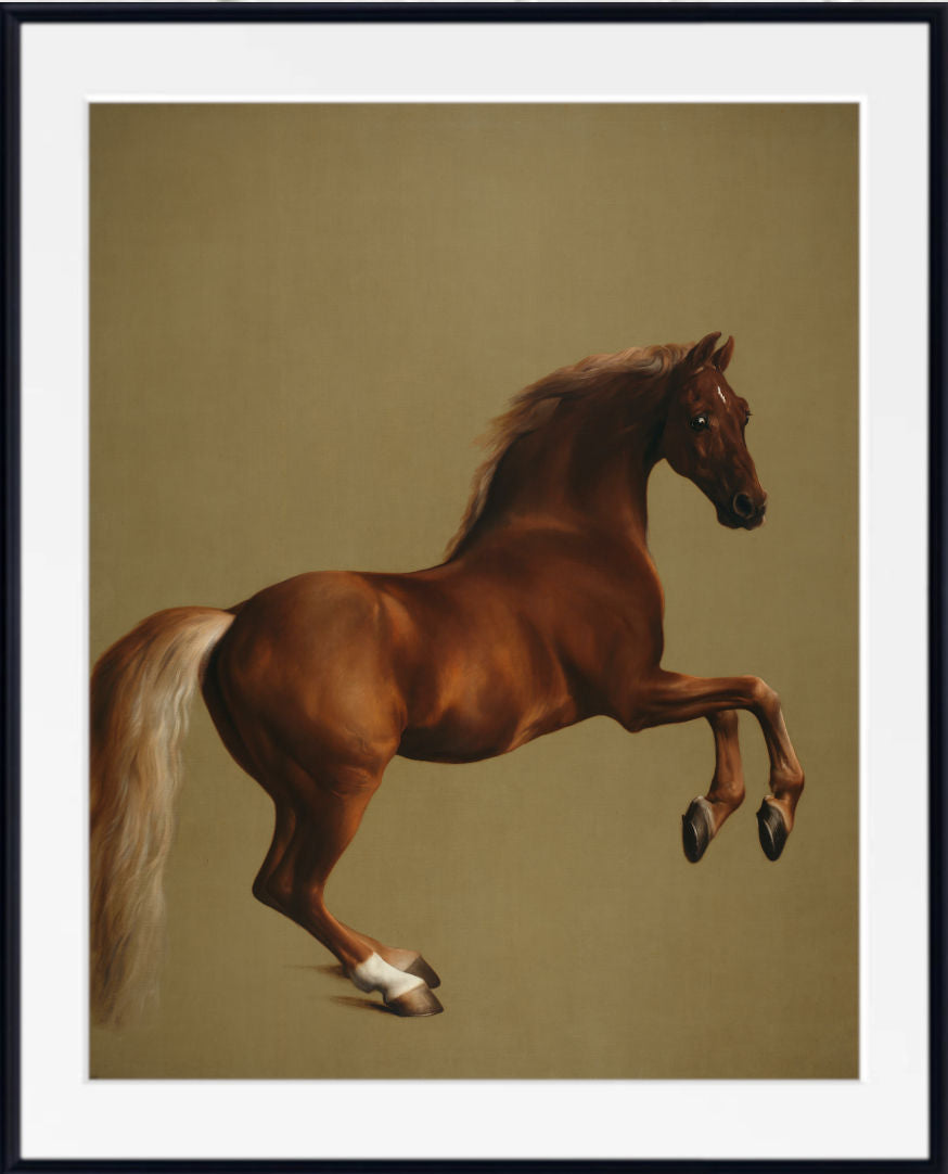 A framed art print featuring a painted brown horse rearing up against a warm beige background, with a wide white mat and a black frame.