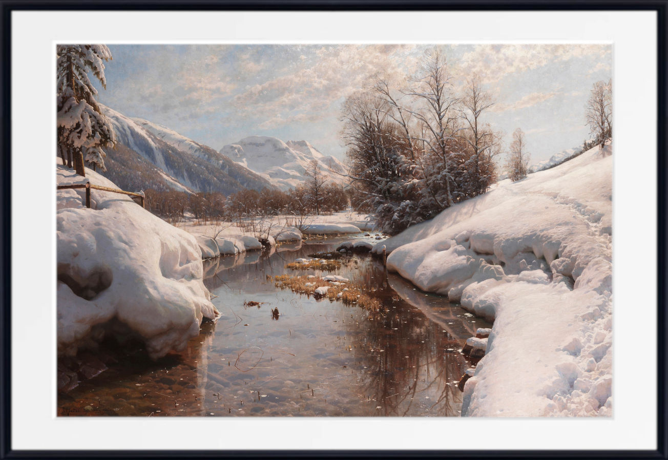 A framed landscape painting depicting a snowy winter valley with a small stream, snow-covered trees, and mountains under a cloudy sky, shown with a wide white mat and black frame.