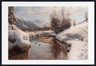 A framed landscape painting depicting a snowy winter valley with a small stream, snow-covered trees, and mountains under a cloudy sky, shown with a wide white mat and black frame.