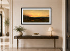 Amaldus Nielsen Print, Solnedgang ved seteren (1866) displayed above a console table