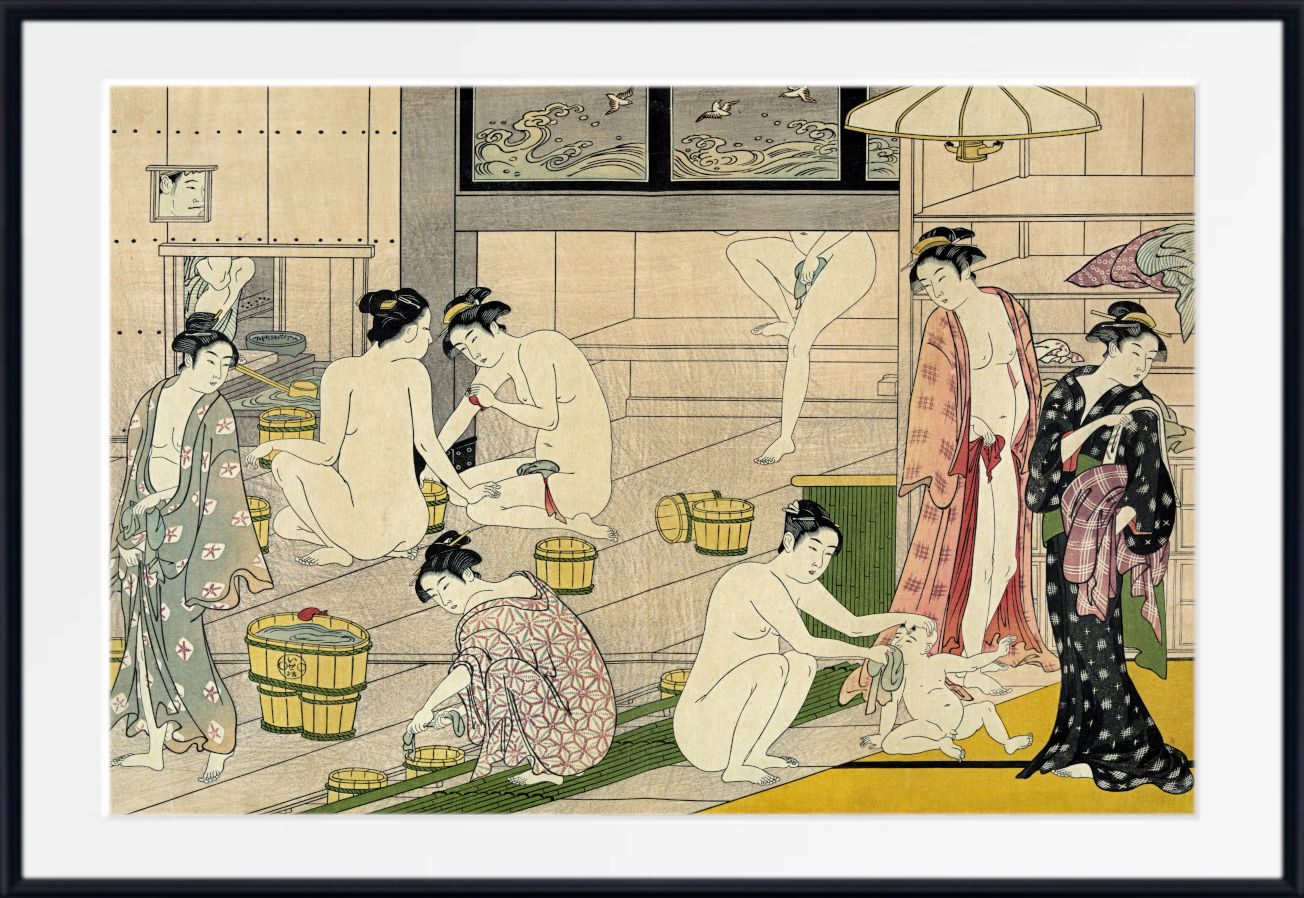 A framed Japanese ukiyo-e woodblock print depicting several women in a bathhouse, with one nude woman standing near a tub and others in patterned kimonos. The print is shown with a wide white mat and a black frame against a light gray background.
