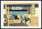 A framed Japanese ukiyo-e woodblock print depicting figures in blue and beige garments within a building, with a white mat and black frame around the artwork.